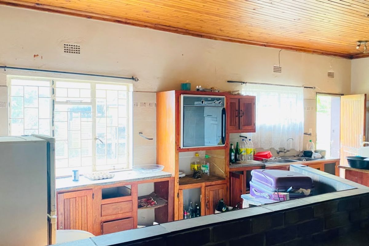 A dated kitchen featuring timber ceilings, built-in wooden cabinetry, and a built-in oven, offering significant potential for a modern renovation.