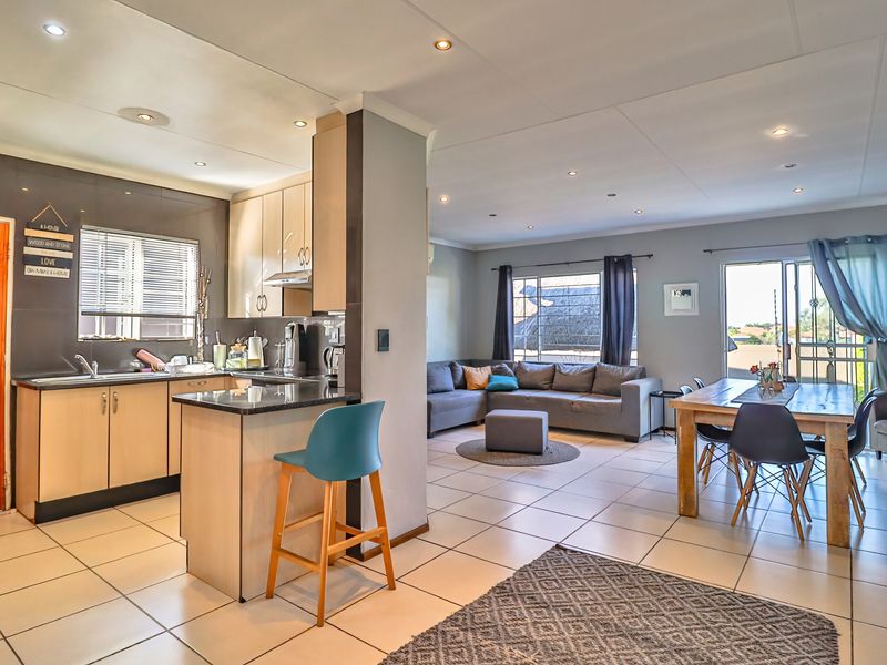 Spacious open-plan living area featuring a modern kitchen with granite countertops, tiled flooring, and seamless flow to the dining and lounge spaces.