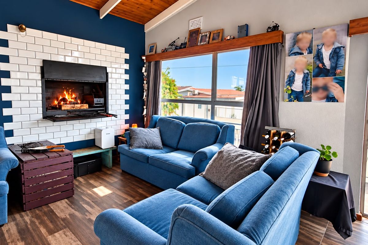 A cozy living room featuring a built-in fireplace with a white subway tile surround, exposed timber ceiling beams, and large sliding doors leading outdoors.