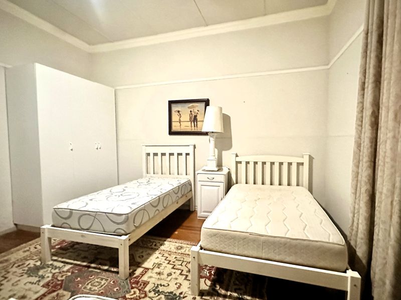 A bedroom featuring a built-in wardrobe, picture rails, and coved ceiling details, providing a functional space with neutral wall finishes.