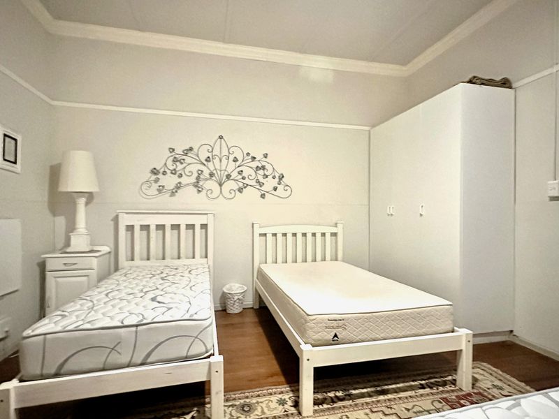 A bedroom featuring a built-in wardrobe, decorative coving, and picture rails, providing a functional space with classic architectural details.