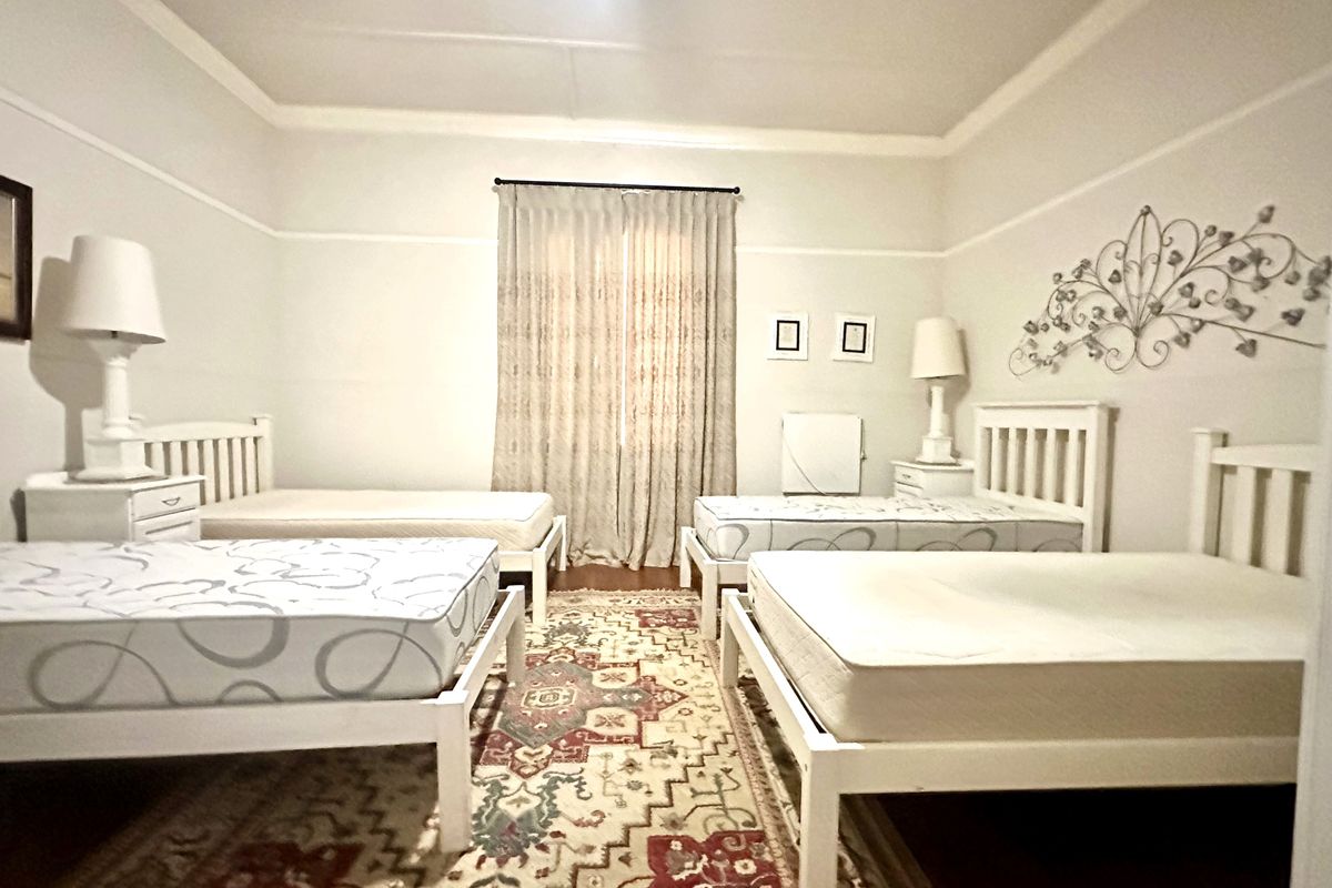 A spacious bedroom featuring high ceilings with coved detailing and a classic picture rail, providing a neutral foundation for various interior design styles.
