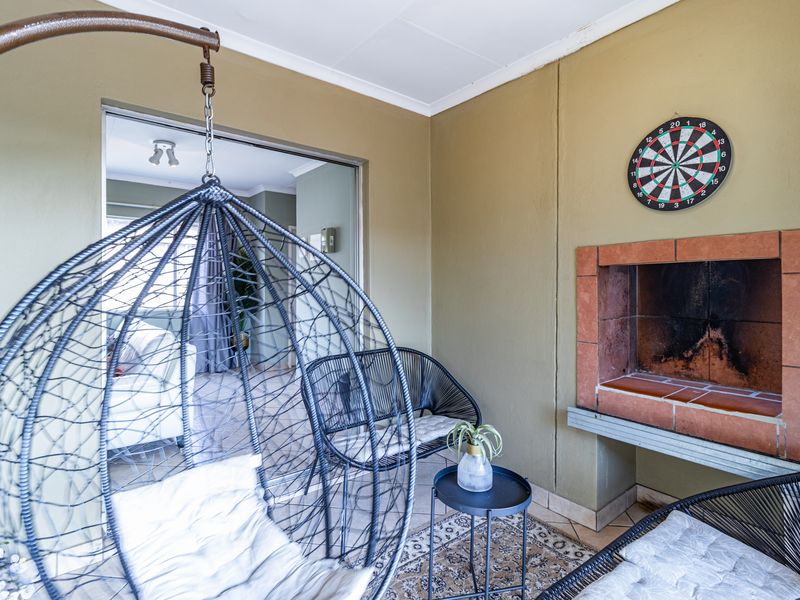 Covered patio area featuring a built-in fireplace and direct access to the interior living space through sliding glass doors.