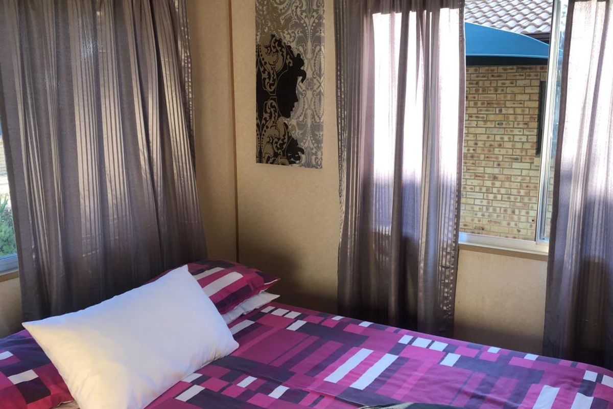 A bedroom featuring dual windows with views of the exterior brickwork and surrounding property.