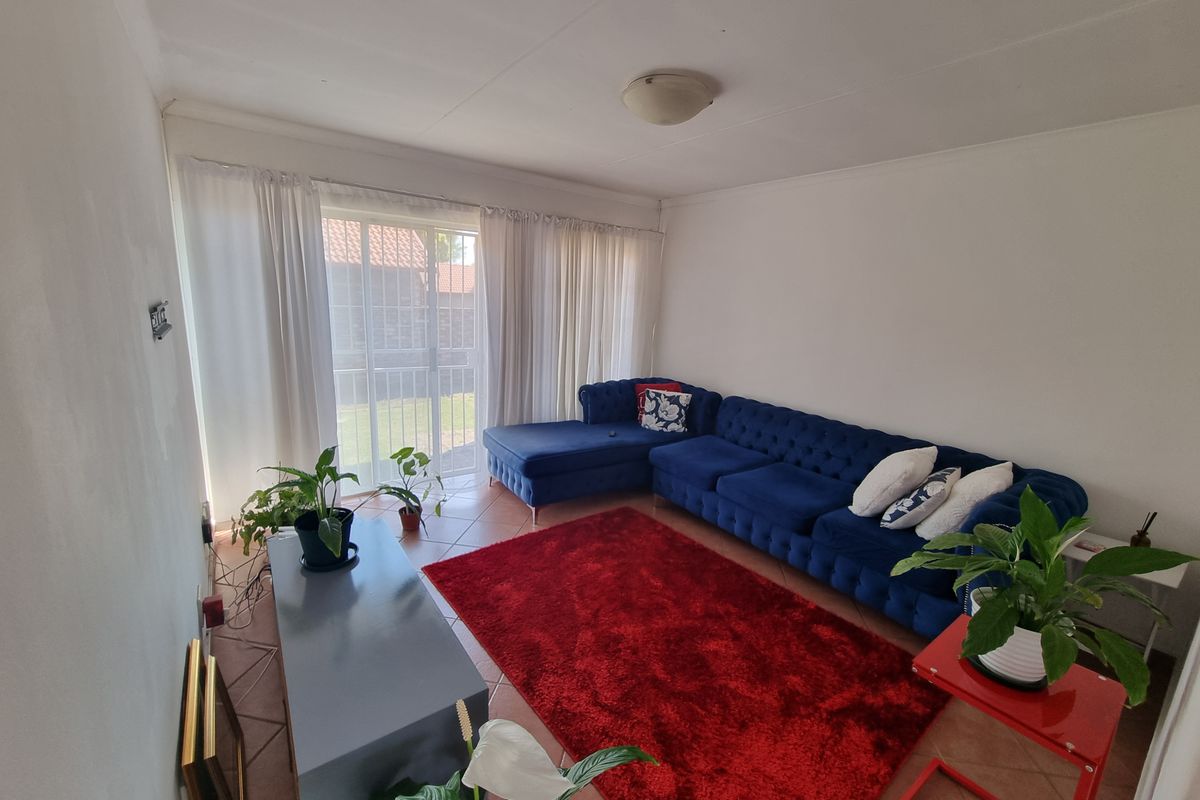 A living room featuring tiled flooring and a large sliding glass door providing access to the exterior.