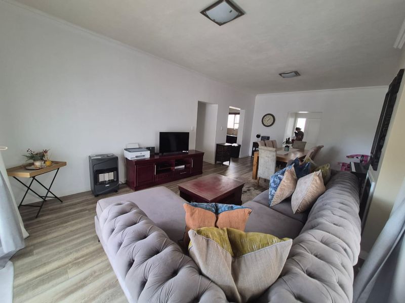 Spacious open-plan living and dining area featuring modern laminate flooring and neutral wall finishes, providing a versatile layout for comfortable daily living.