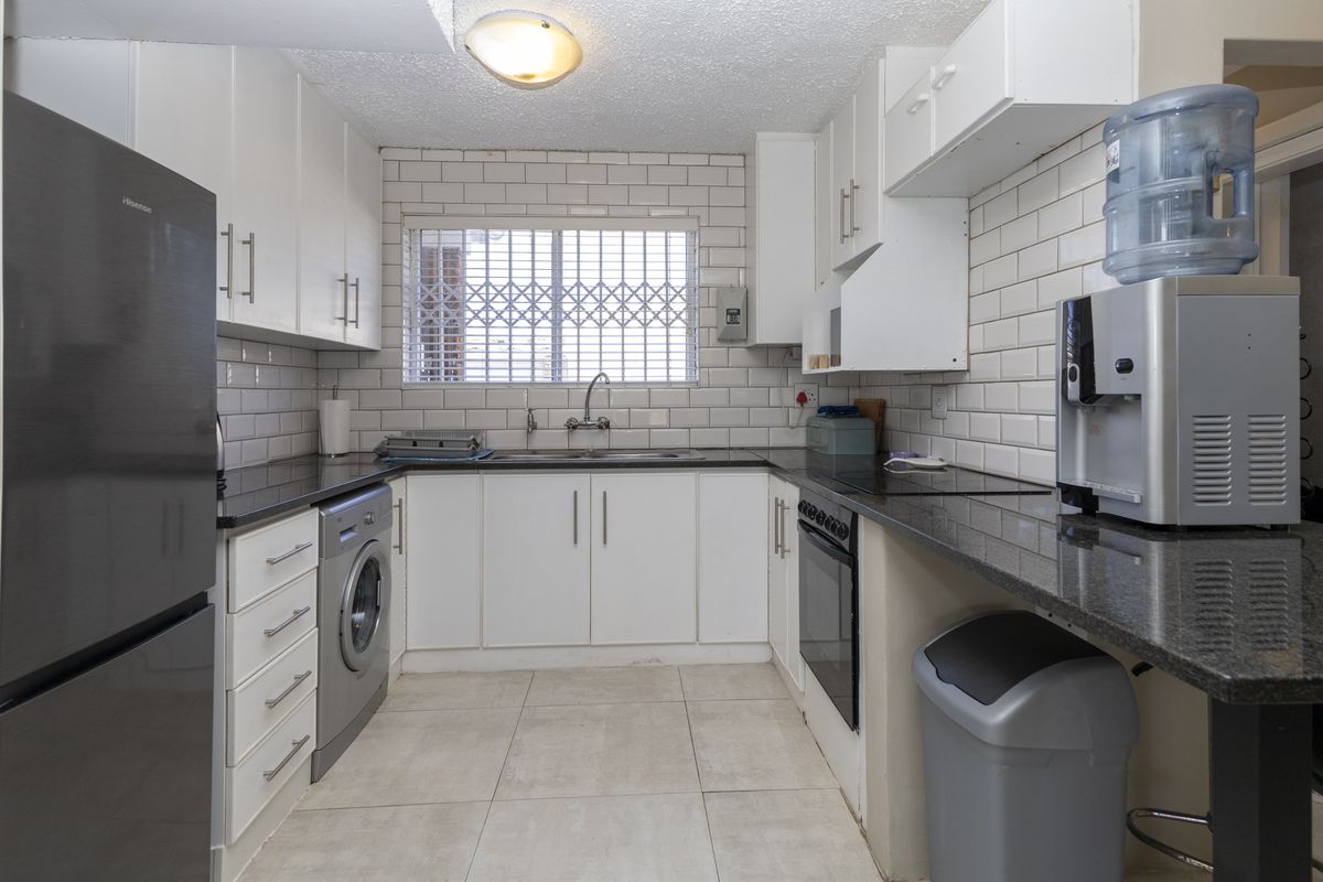 Functional kitchen featuring white cabinetry, granite countertops, subway tile backsplash, and integrated oven, providing a practical workspace with ample storage.