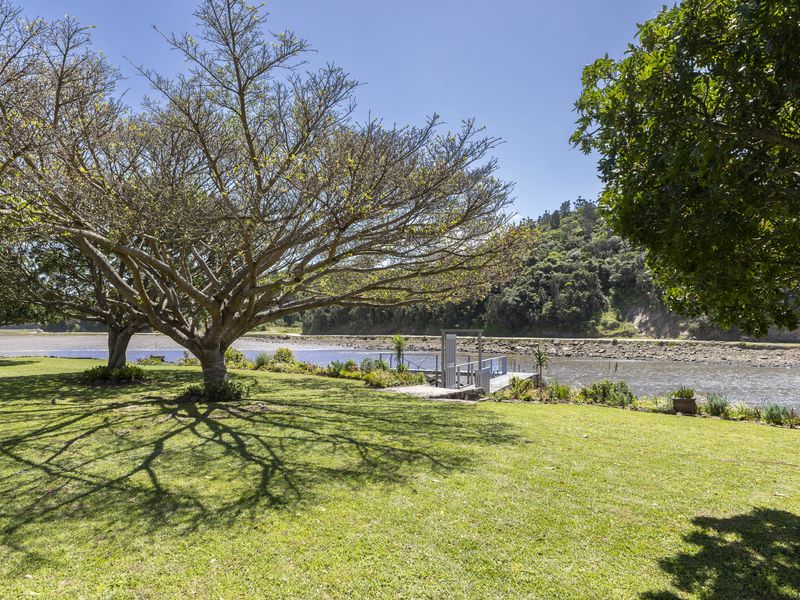 A beautifully maintained garden featuring mature trees and a private jetty with direct access to the riverfront.