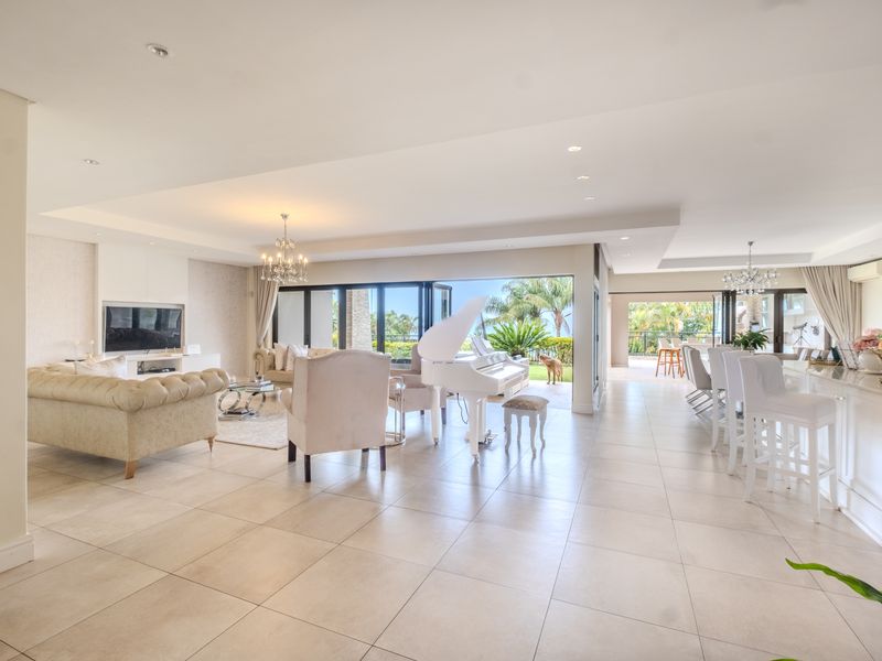 Spacious open-plan living and dining area featuring large bi-fold doors that open to an outdoor patio, complemented by modern tiled flooring and recessed lighting.