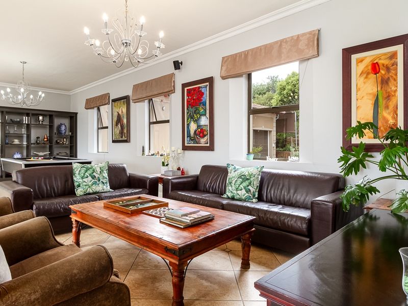 Spacious living room featuring tiled flooring, built-in display shelving, and large windows with natural light, creating a comfortable and inviting atmosphere.
