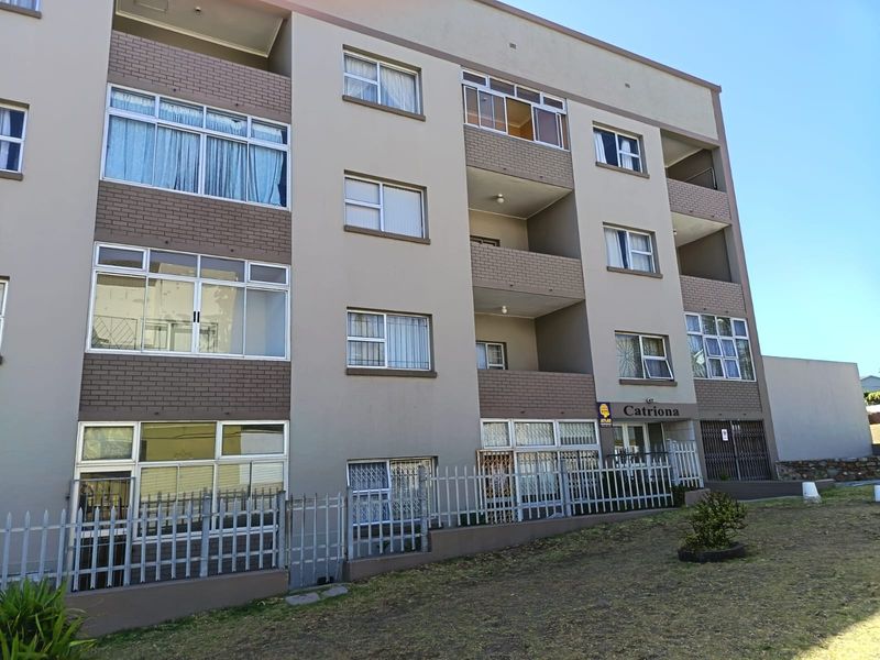 Front elevation of the Catriona apartment building featuring multi-story brick and plaster facade with aluminum windows and secure perimeter fencing.