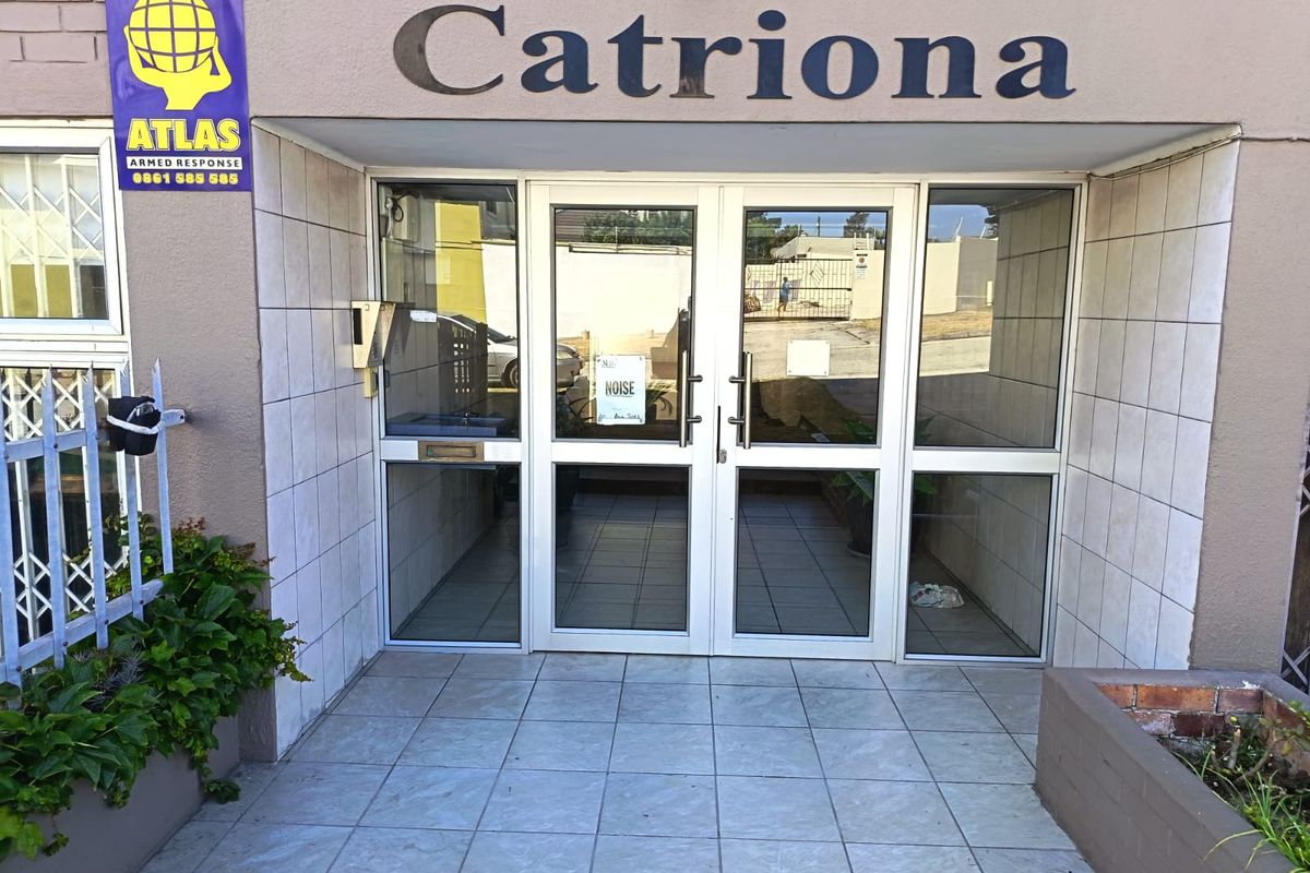 The entrance to the Catriona apartment building features double glass doors, tiled flooring, and an intercom system, providing secure access to the complex.