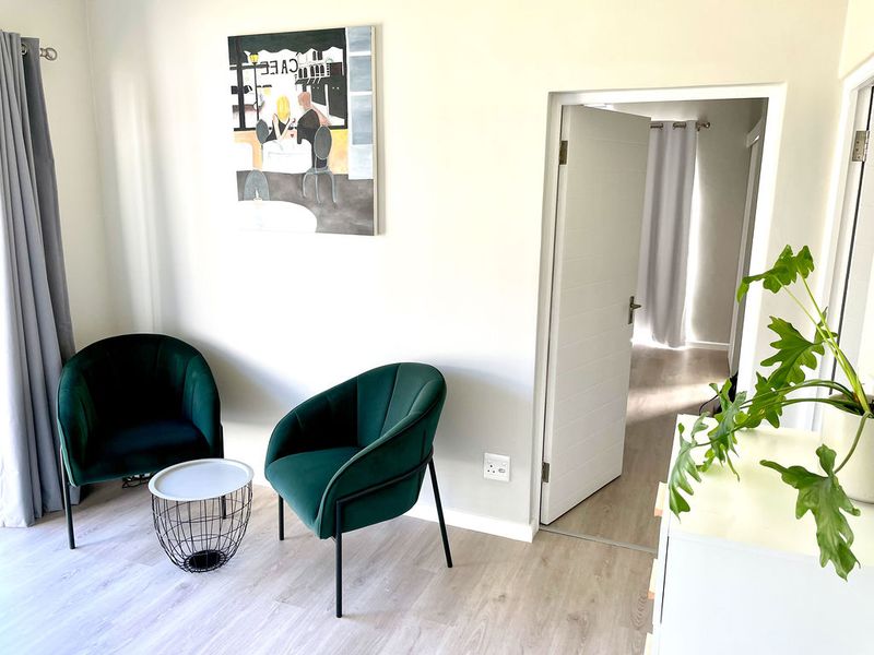 A bright living area featuring light-toned laminate flooring and a neutral interior finish, providing a clean and modern aesthetic.