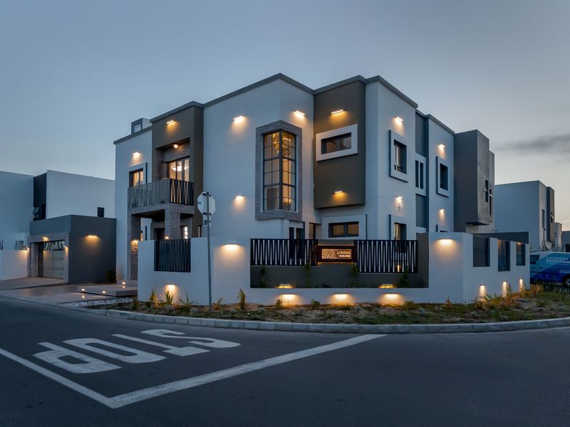 A modern, well-maintained double-story residential property featuring contemporary architectural design, integrated exterior lighting, and a secure boundary wall with metal fencing.