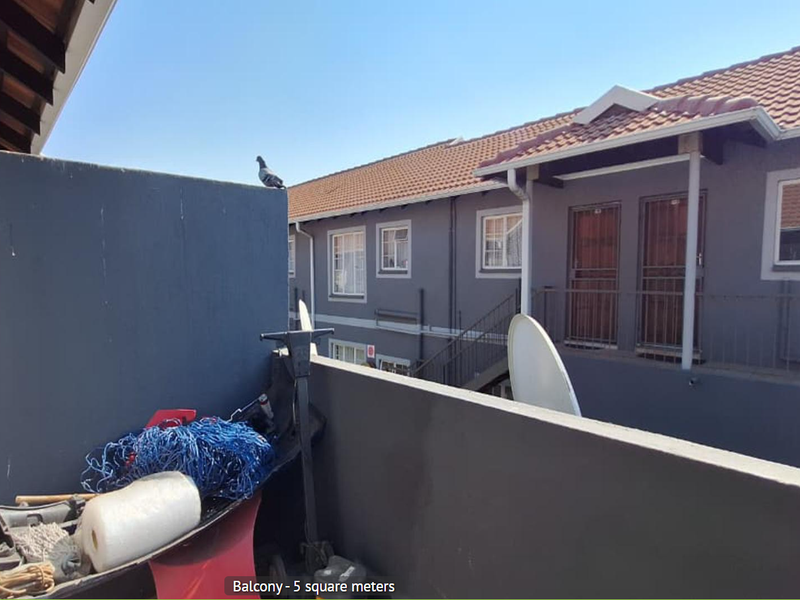 A compact 5 square meter balcony overlooking the apartment complex courtyard with a view of the adjacent building facade.