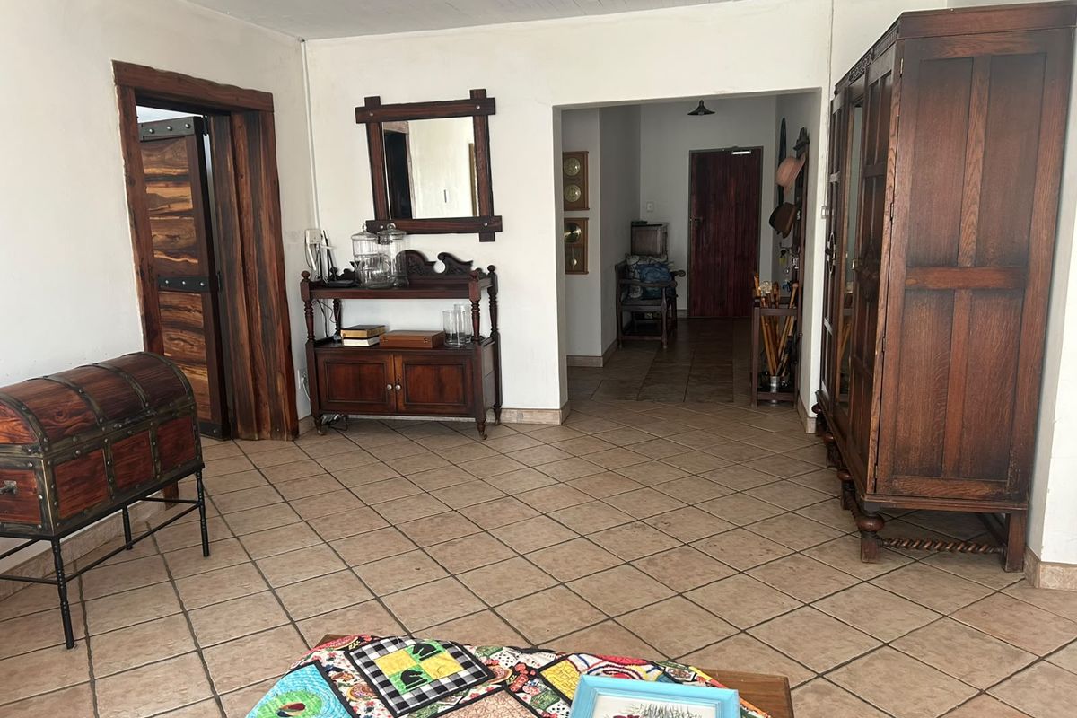 A living area featuring tiled flooring, timber door frames, and a tongue and groove ceiling, providing a rustic aesthetic.