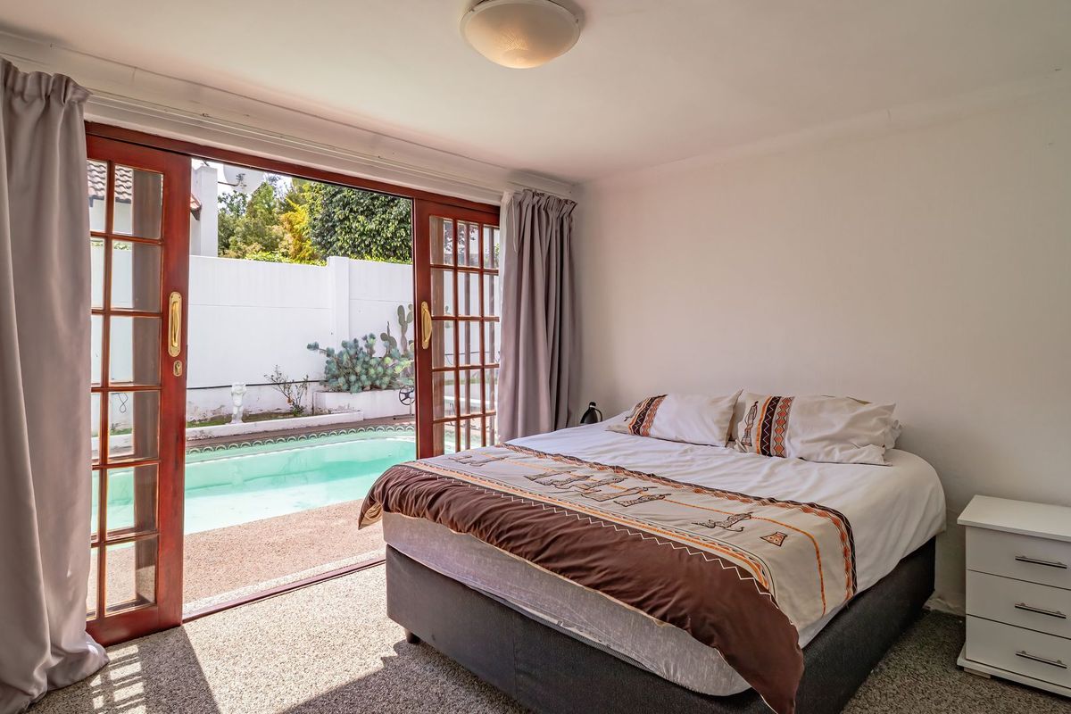 Bedroom featuring carpet flooring and sliding glass doors that open directly onto a private swimming pool area.