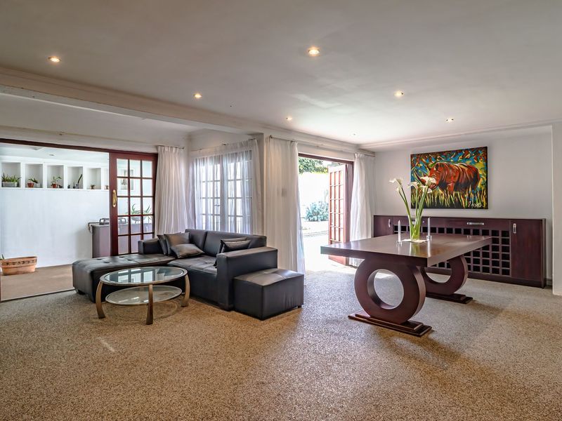 Spacious living area featuring recessed lighting, built-in wine storage, and multiple sets of doors providing seamless access to the outdoor patio area.