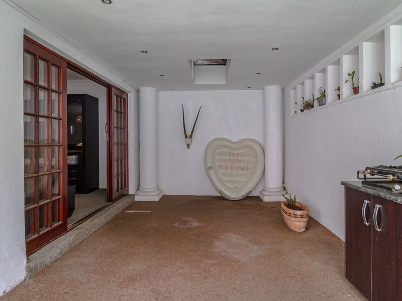 A covered patio area featuring built-in cabinetry, recessed lighting, a skylight, and sliding glass door access to the interior living space.