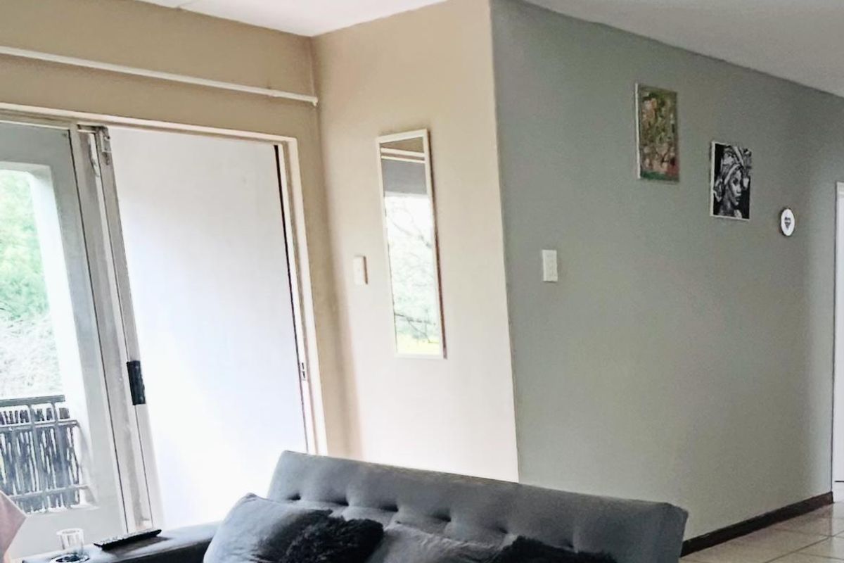 A living room featuring tiled flooring and a sliding glass door providing access to an outdoor area.