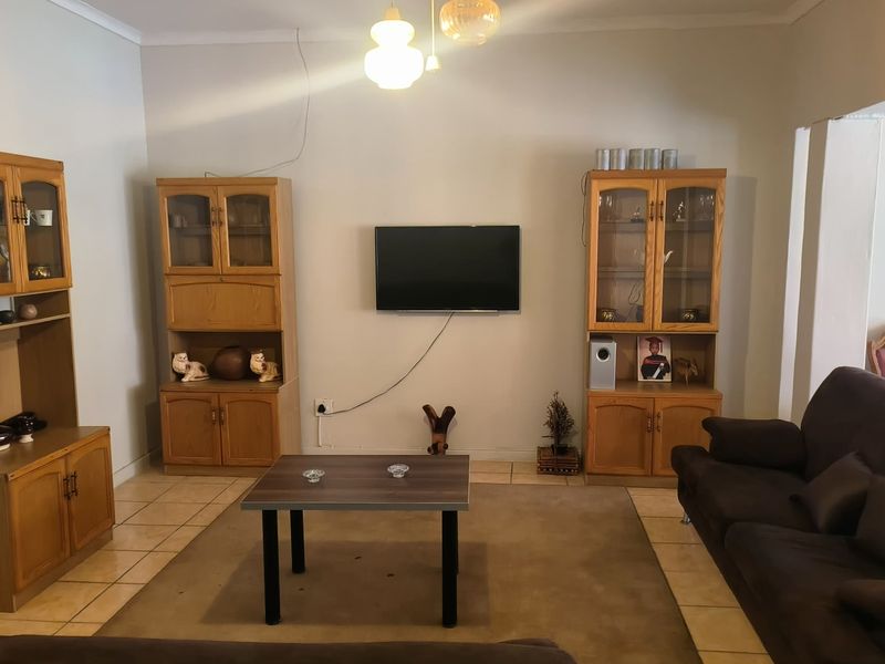 A living room featuring tiled flooring and central ceiling lighting, providing a functional space for relaxation and entertainment.