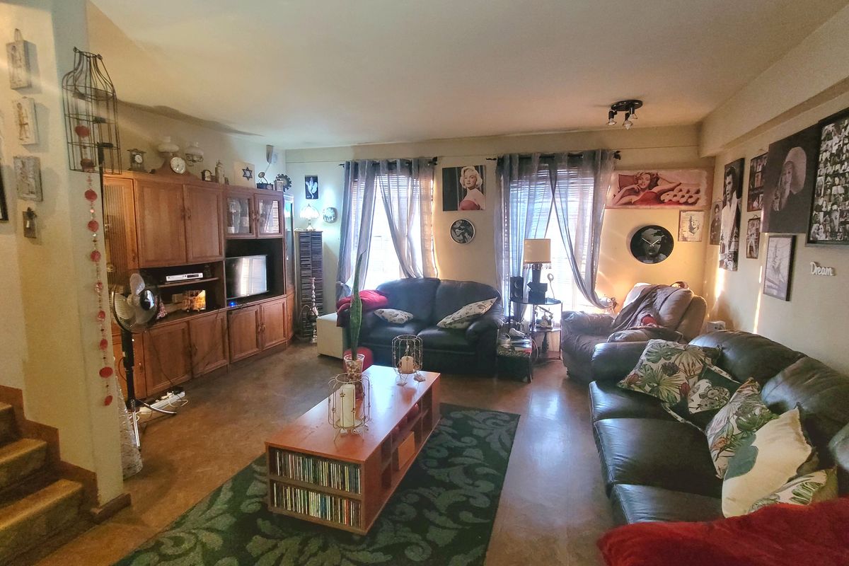 A spacious living room featuring built-in wooden cabinetry and laminate flooring, offering a comfortable and functional layout for relaxation.