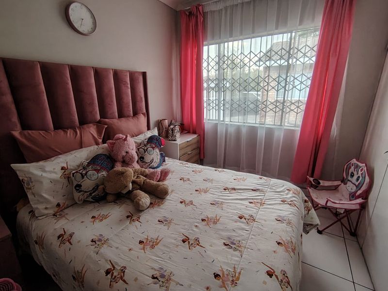 A bedroom featuring tiled flooring and a window fitted with a security gate.