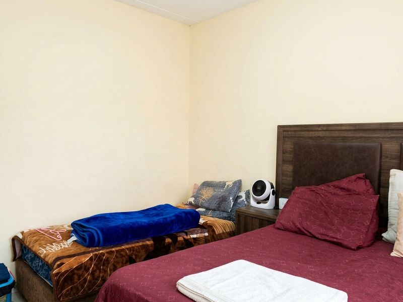 A functional bedroom space featuring neutral wall finishes, suitable for comfortable living.
