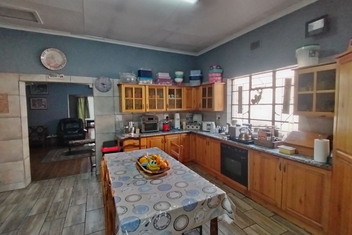 A functional kitchen featuring wooden cabinetry, built-in oven, and tiled flooring, offering a traditional layout with ample storage and workspace.
