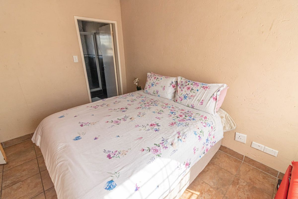 A bedroom featuring tiled flooring and direct access to an en-suite bathroom.