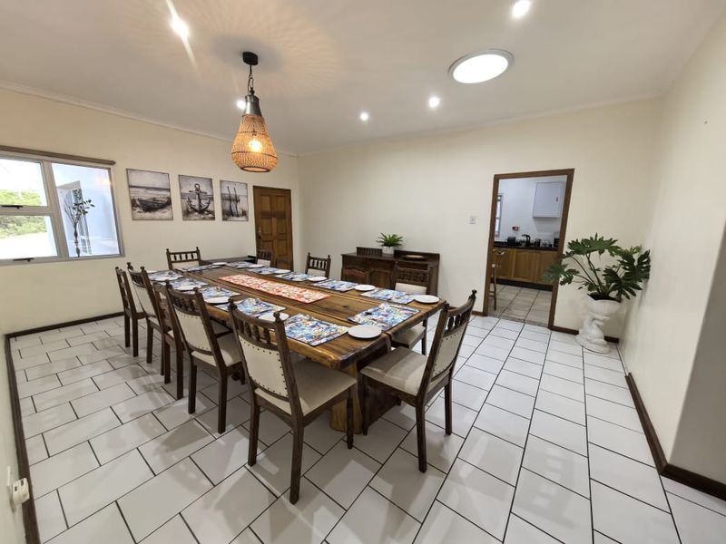Spacious dining room featuring ceramic tiled flooring, recessed downlighting, and a skylight, with direct access to the adjacent kitchen area.