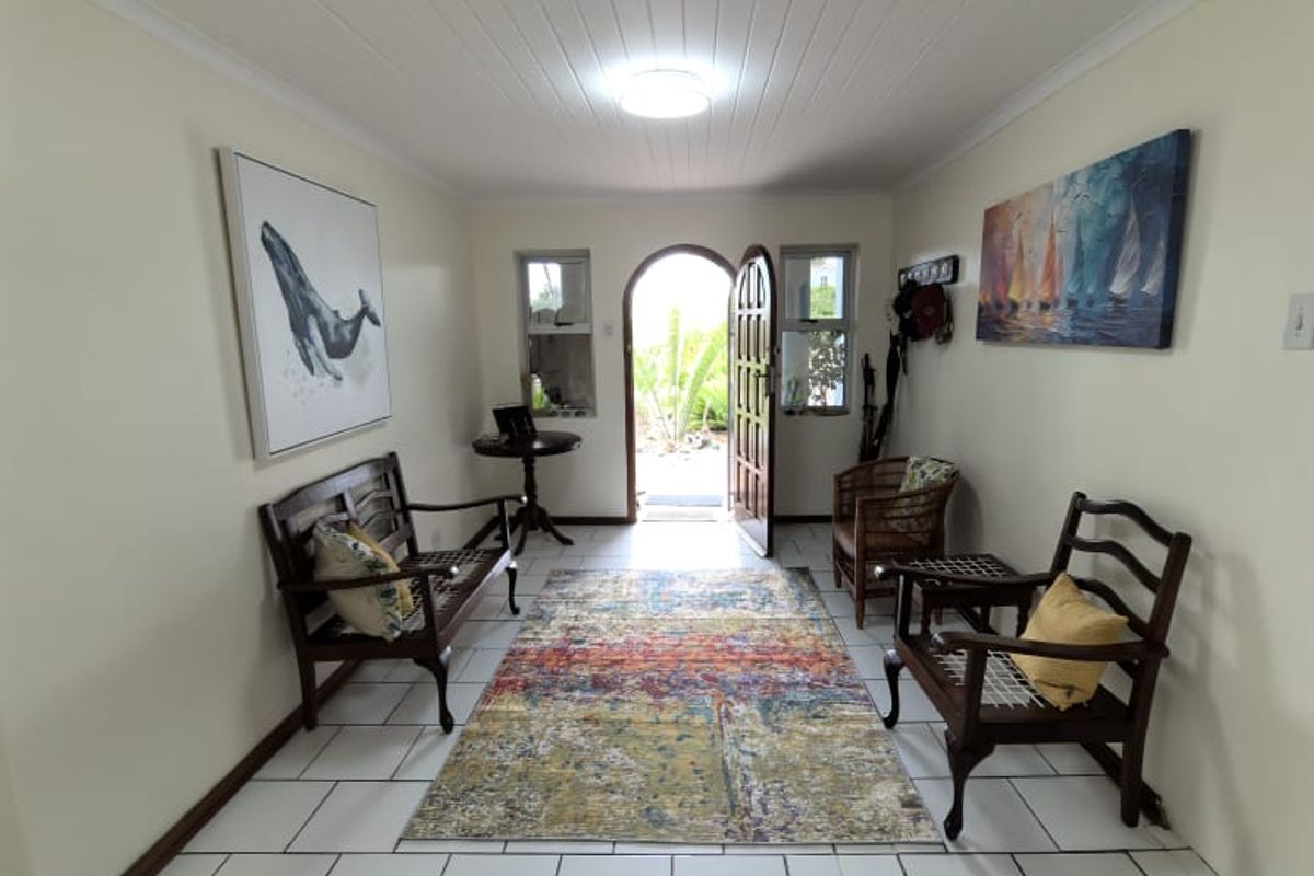 Welcoming entrance hall featuring tiled flooring, a tongue and groove ceiling, and an arched front door leading to the exterior.