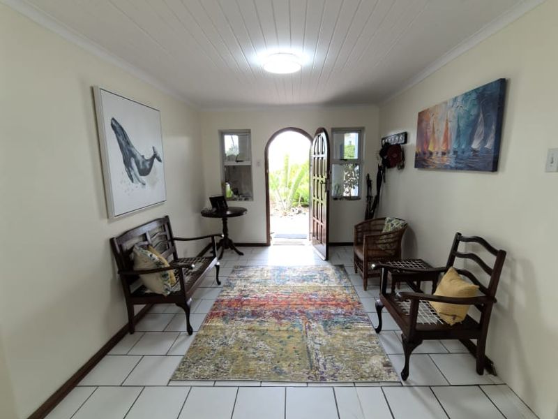 Welcoming entrance hall featuring tiled flooring, a tongue and groove ceiling, and an arched front door leading to the exterior.