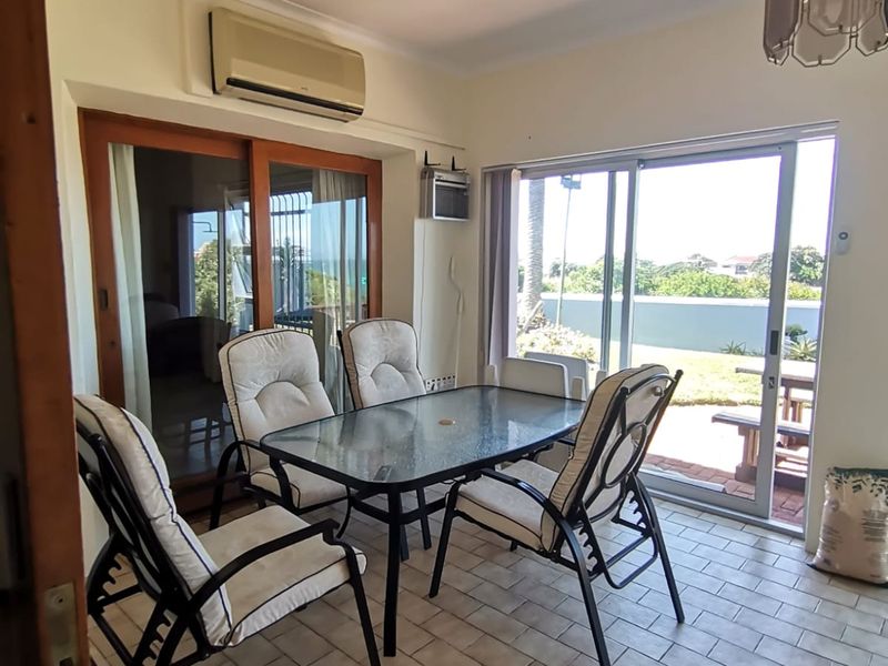 Dining area featuring tiled flooring, split-system air conditioning, and large sliding glass doors providing access to the outdoor space.