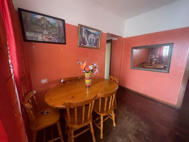 Dining room featuring traditional parquet flooring and painted walls, requiring cosmetic updates to modernize the space.