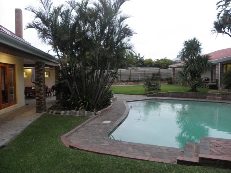 A well-maintained outdoor area featuring a swimming pool, brick-paved surround, and a covered patio space, ideal for relaxation and outdoor entertaining.