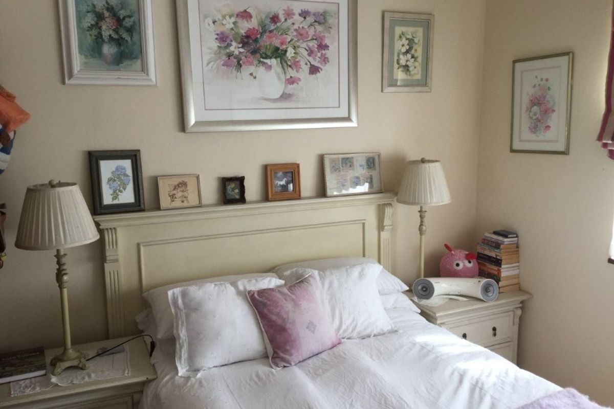 A cozy bedroom featuring a neutral color palette and a built-in headboard, providing a comfortable and functional sleeping space.