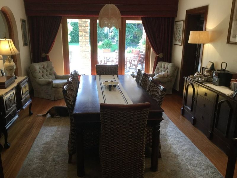 A formal dining room featuring hardwood flooring and sliding glass doors that provide direct access to the outdoor patio area.