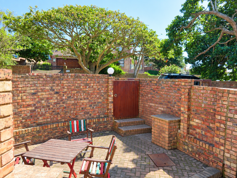 A private outdoor patio area featuring face-brick walls, paved flooring, and a built-in brick braai, providing a secluded space for outdoor entertaining.