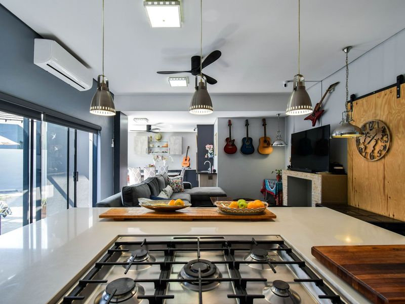 Open-plan living area featuring a modern kitchen island with a built-in gas hob, flowing seamlessly into a spacious lounge and dining space.