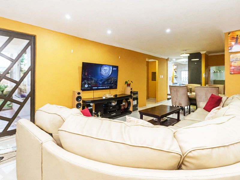 Open-plan living area featuring tiled flooring, recessed lighting, and a sliding glass door providing access to the outdoor space.