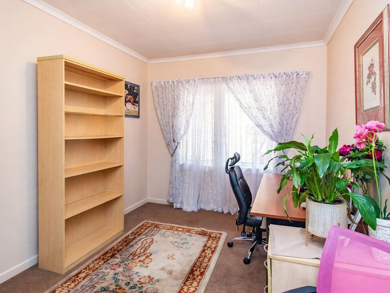 A functional home office space featuring carpeted flooring and a coved ceiling, providing a quiet area suitable for remote work or study.