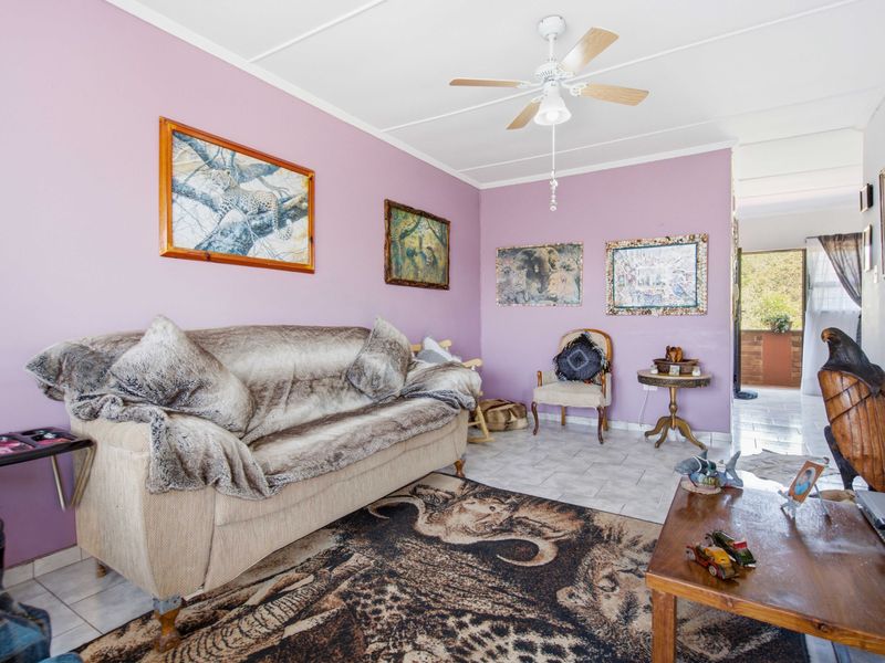 A living room featuring tiled flooring and a ceiling fan, with access to an adjacent outdoor area.