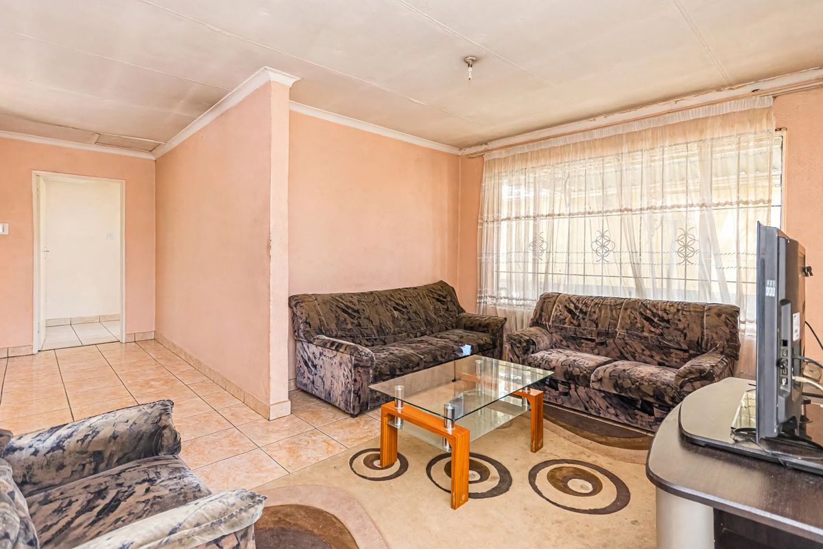 A living room featuring tiled flooring and coved ceilings, offering a functional space with potential for cosmetic updates to enhance its appeal.