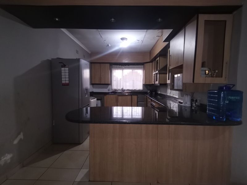 Kitchen featuring laminate cabinetry, granite countertops, and a breakfast bar. The space requires ceiling repairs and cosmetic updates to improve its overall condition.