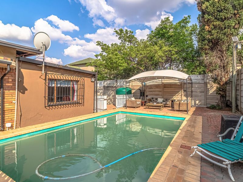Outdoor pool area featuring a swimming pool, brick paving, and perimeter walling, providing a functional space for recreation and relaxation.