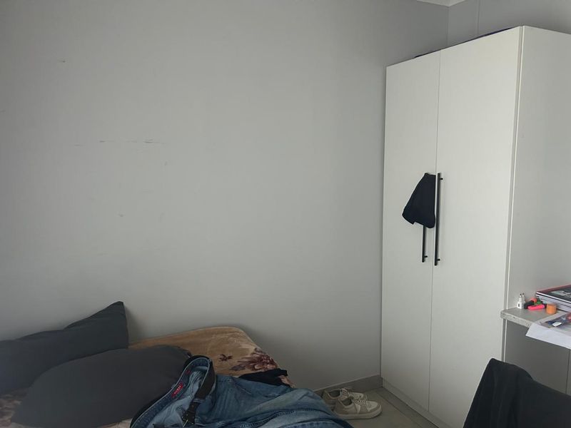 A bedroom featuring a built-in wardrobe and neutral wall finishes, offering a functional space ready for personalization.