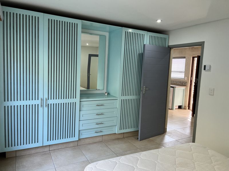 Bedroom featuring extensive built-in cabinetry with integrated vanity, tiled flooring, and recessed lighting, providing ample storage and a functional layout.
