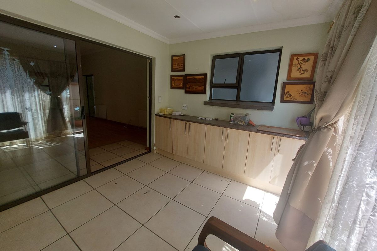 A living area featuring tiled flooring, built-in cabinetry, and a large sliding glass door providing access to the exterior.