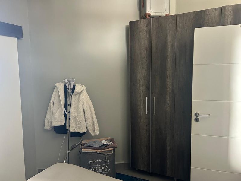 A bedroom featuring a dark wood-finish built-in wardrobe and a modern white internal door.